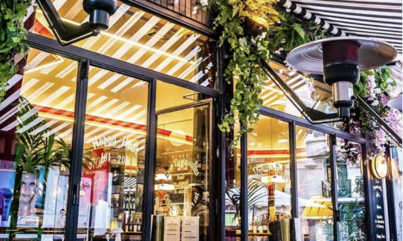 La vitrine fleurie sous le store rayé